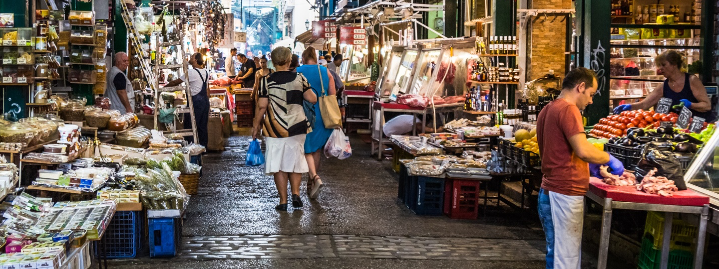 People walking through an open air market with many vendors