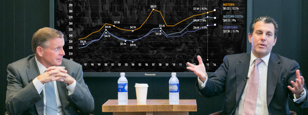 2 men in suits discussing a chart of pricing data